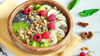 green smoothie bowl topped with fruit and nuts