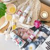 six mayella products in this before & after skin set laying flat on an open magazine and on a netted, cotton shopping bag. They're surrounded by decorative items like a tea candle, a red rose and slices of lemon