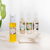four Mayella skincare products that make up this pack, the cleansing serum standing on a white blanket with three remaining products standing on a stack of stone coasters next to it