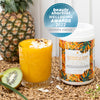 Glass of Mango smoothie with half of a kiwifruit, full pineapple in the background. Next to a container of Mayella Sunshine & Hemp Protein Blend. The Beauty Shortlist logo 2022 Editors Choice  award on the container.