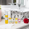 five mayella skincare products that make up this pack, standing on a white bathroom vanity with a black and white floral-patterned sink in the background